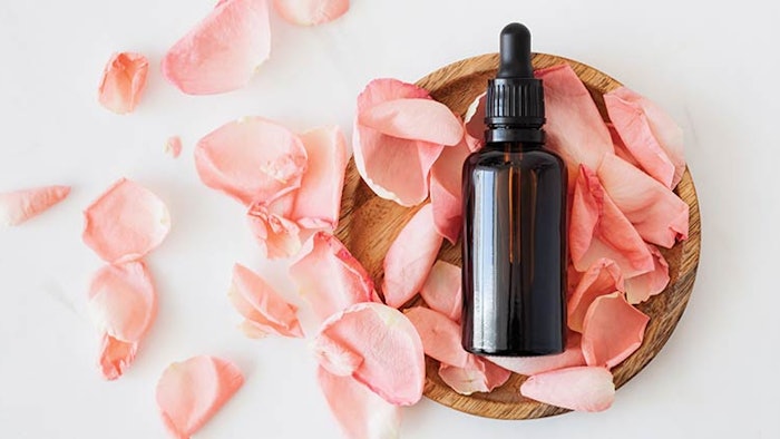 Skin care product laying on a bed of rose petals.