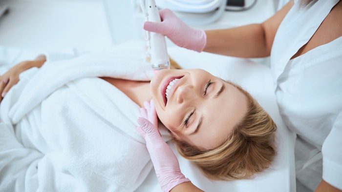 Woman getting microneedling treatment on neck