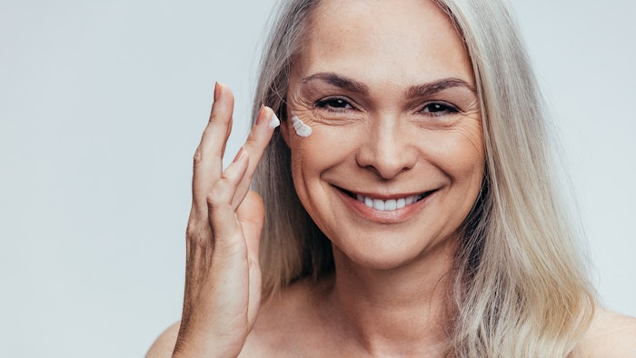Woman putting eye cream on
