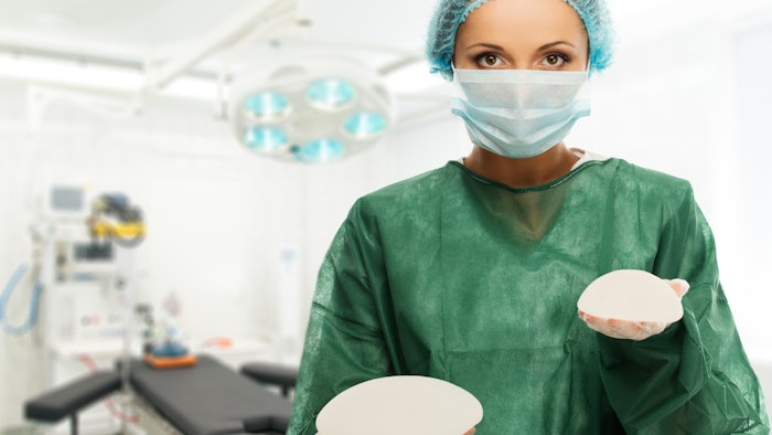 Doctor holding breast implants