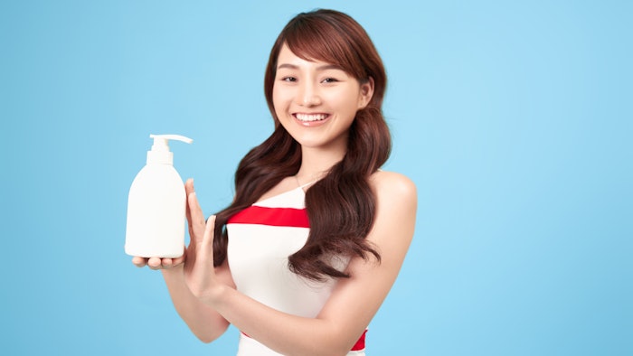 Woman holding bottle of lotion