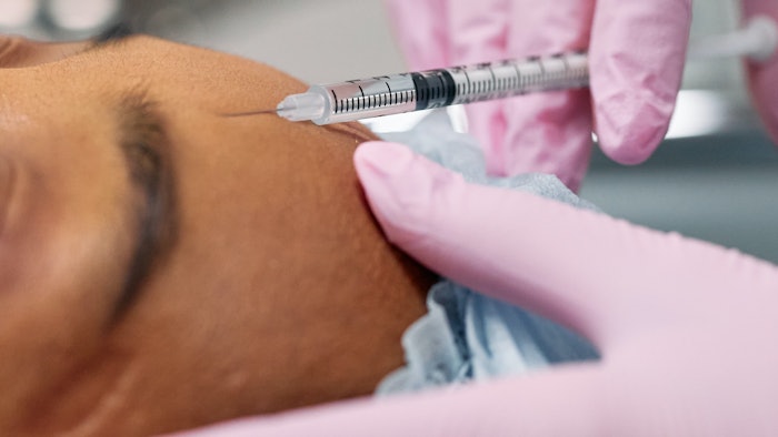Woman receiving botulinum toxin injection.