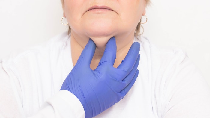 Doctor examining woman's double chin.