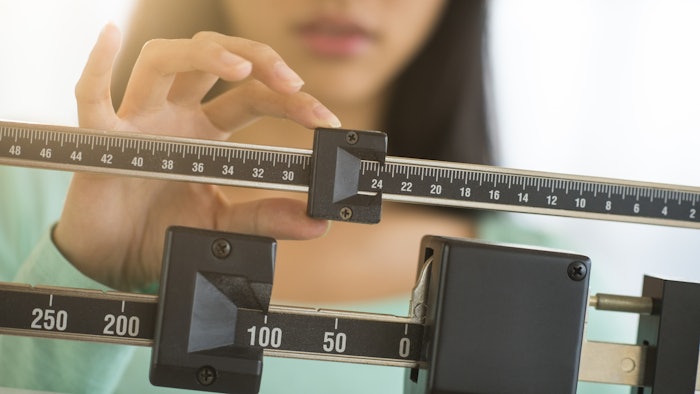 Woman measuring weight on scale
