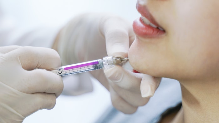 Woman getting chin filler injections