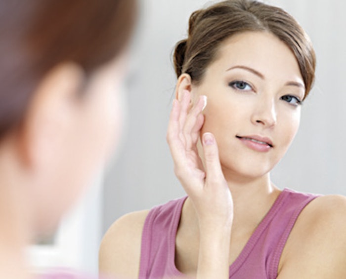 woman observing her skin in the mirror