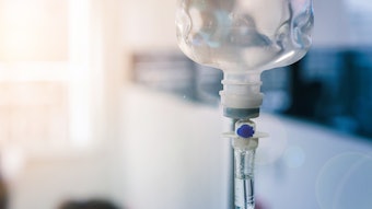 Healthcare concept, Close up of medical drip or IV drip chamber in patient room, Selective focus.