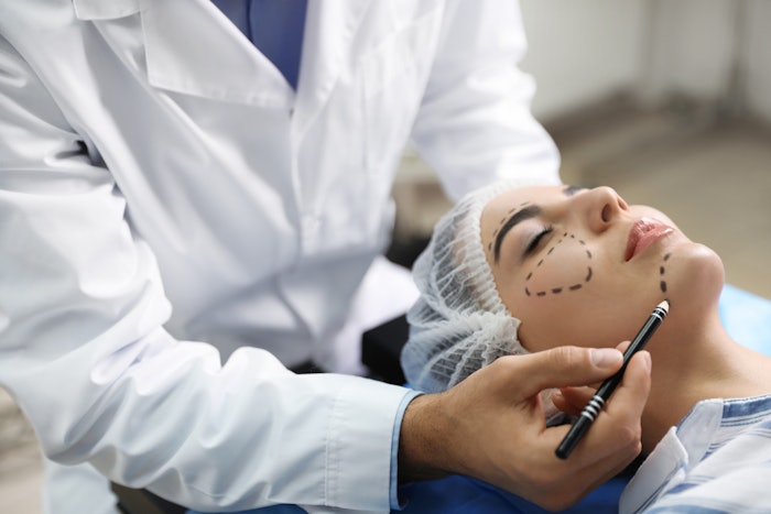 Doctor preparing female patient for cosmetic surgery in clinic