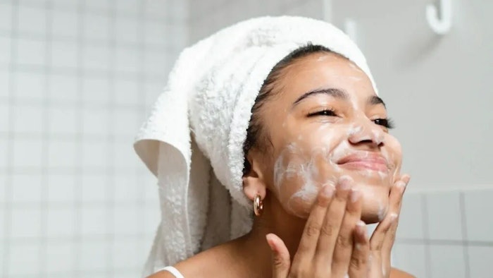 black woman using facial cream