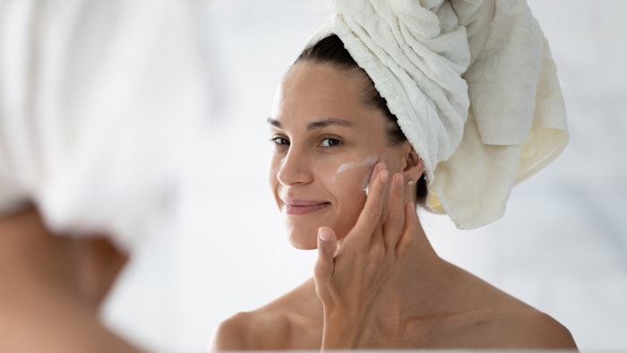 Happy cosmetic product consumer satisfied with moisturizing antiage cream