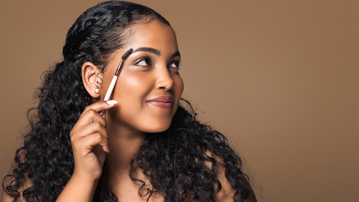 Woman brushing her eyebrows