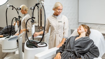 Young woman client with a doctor during a facial rejuvenation treatment at medical SPA office.