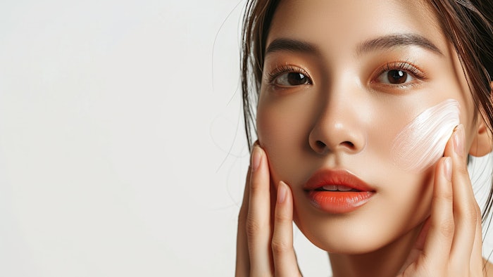 a beautiful Asian woman with a perfect application of face cream