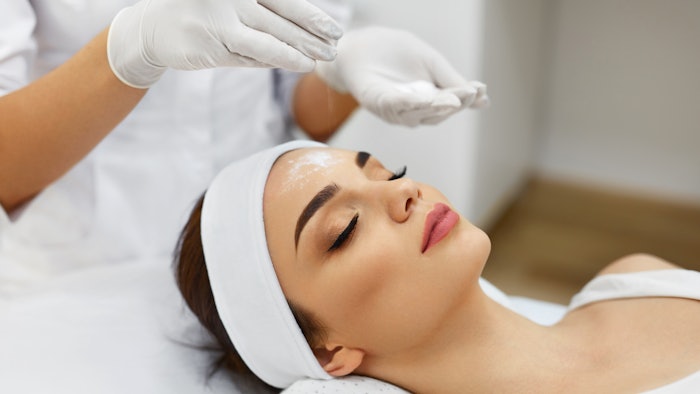 Girl At Spa Salon. Beautician Applying White Cosmetic Powder