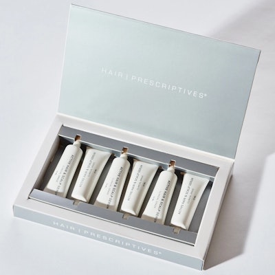 box with lid open containing row of tubes with hair prescriptives hair and scalp serum