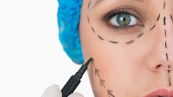 Plastic surgeon marking woman's face