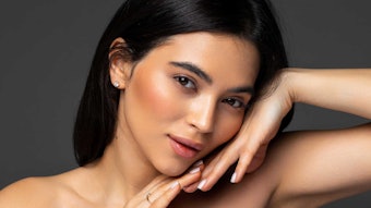 beautiful brunette posing hands under chin slightly smiling
