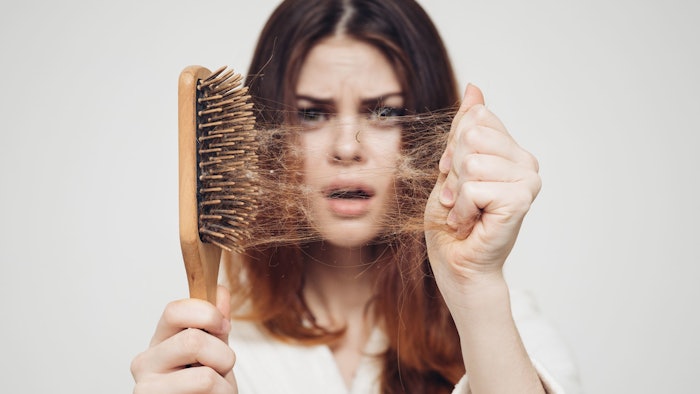 girl with a comb in his hand on a white background distressed hair