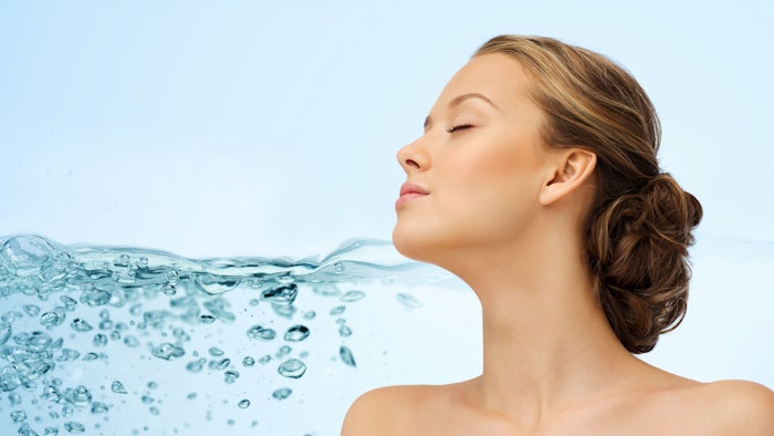 young woman face and shoulders next to water, symbolizing skin hydration