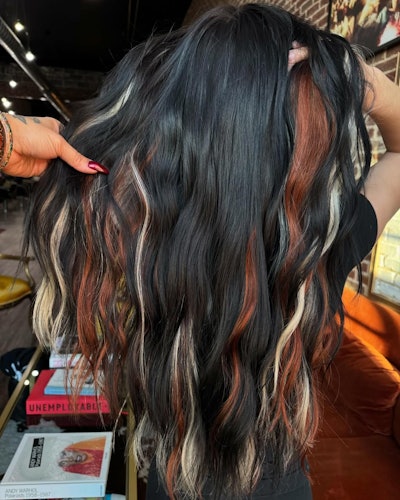Calico hair trend with black hair and copper and blonde peek-a-boo strands.