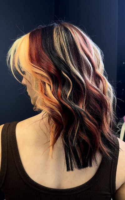Calico hair trend with platinum blonde, dark red and black strands