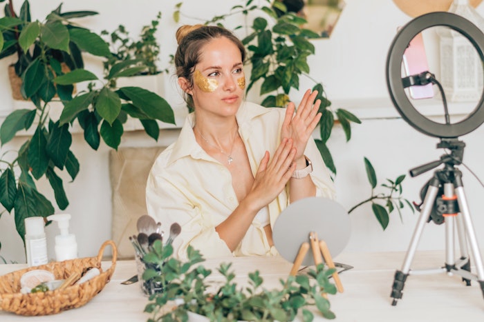 Female skin care influencer filming herself with products