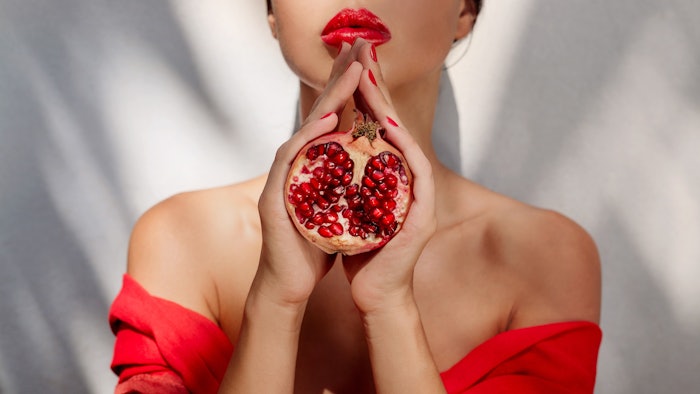 Woman Neck Down Red Dress Cradling Pomegranate