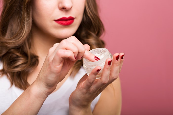 Woman With Red Nails And Lipstick Using Facial Cream Adobe Stock 94437118