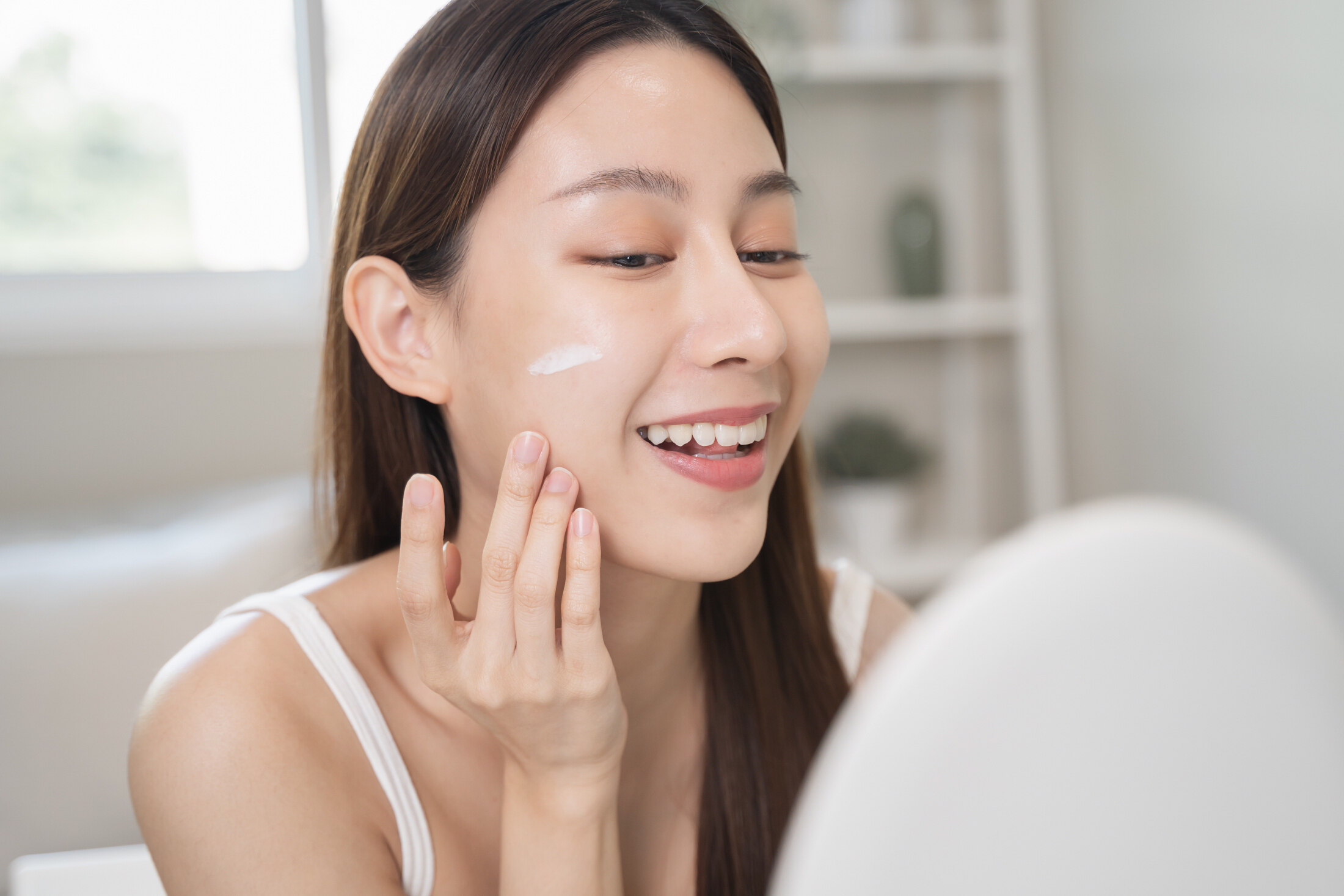 Beautiful Asian Woman Using Skin Care Products