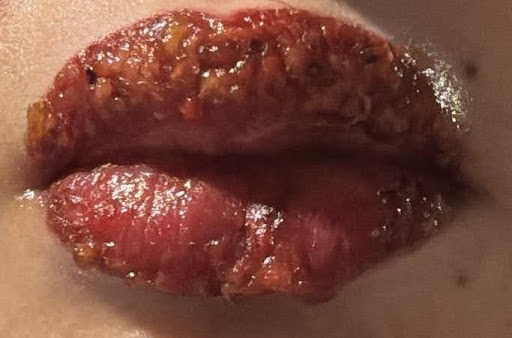Close-up of glossy lips with sparkly cosmetic finish and natural texture