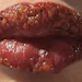 Close-up of glossy lips with sparkly cosmetic finish and natural texture