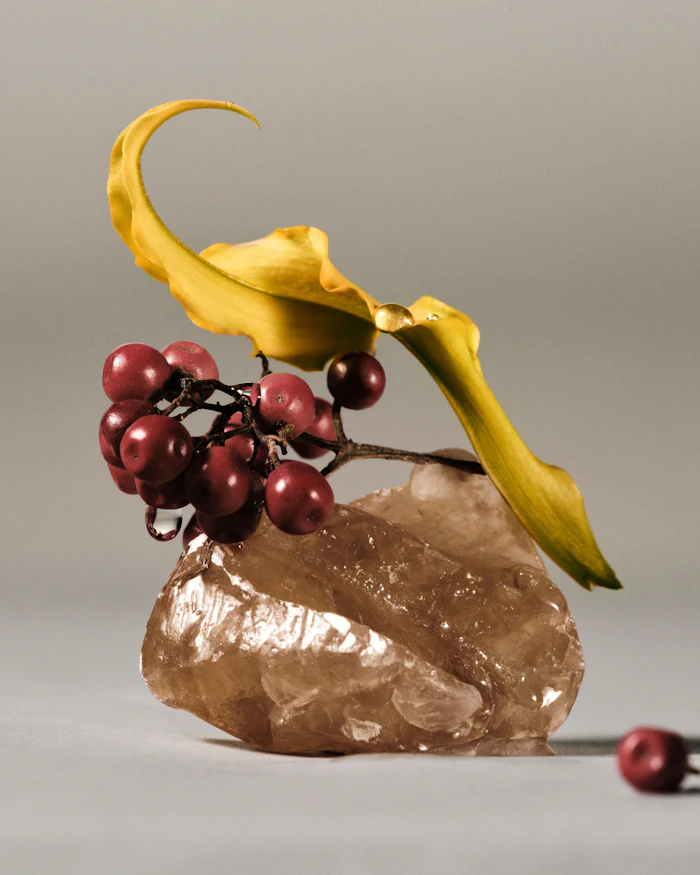 Yellow banana peel and red rowan berries arranged on a textured stone against gray background