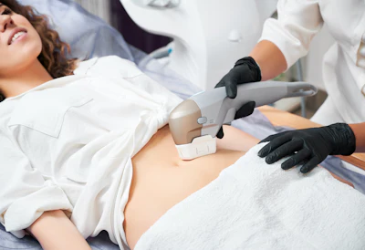 Healthcare professional performing abdominal ultrasound examination on patient wearing white gown