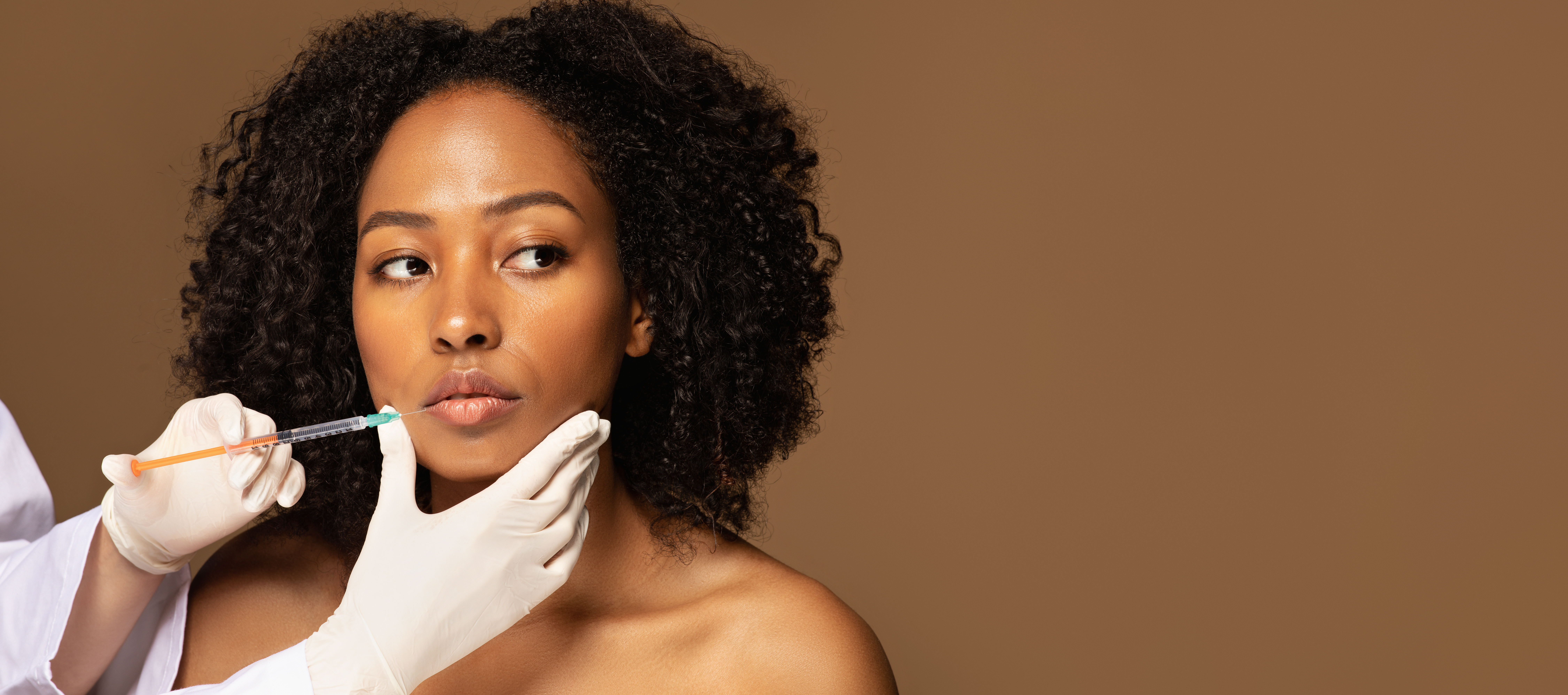 Woman receiving cosmetic injection from healthcare professional during dermatological procedure