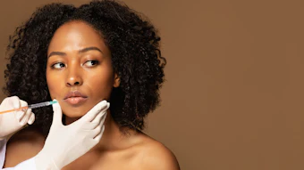 Woman receiving cosmetic injection from healthcare professional during dermatological procedure