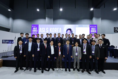 Group photo of ASLS Korea conference attendees in business attire standing in front of purple branded backdrop